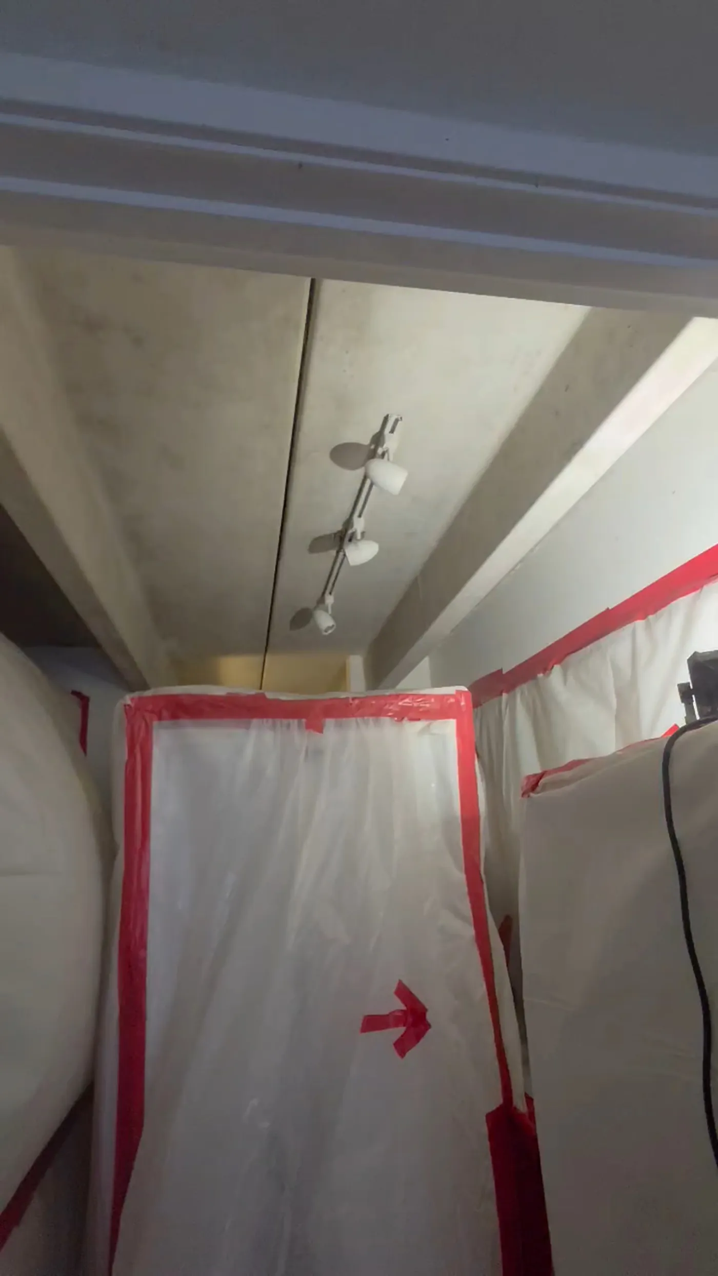 Sealed plastic containment with taped decon chamber and HEPA negative air machine set up for asbestos popcorn ceiling removal in Denver